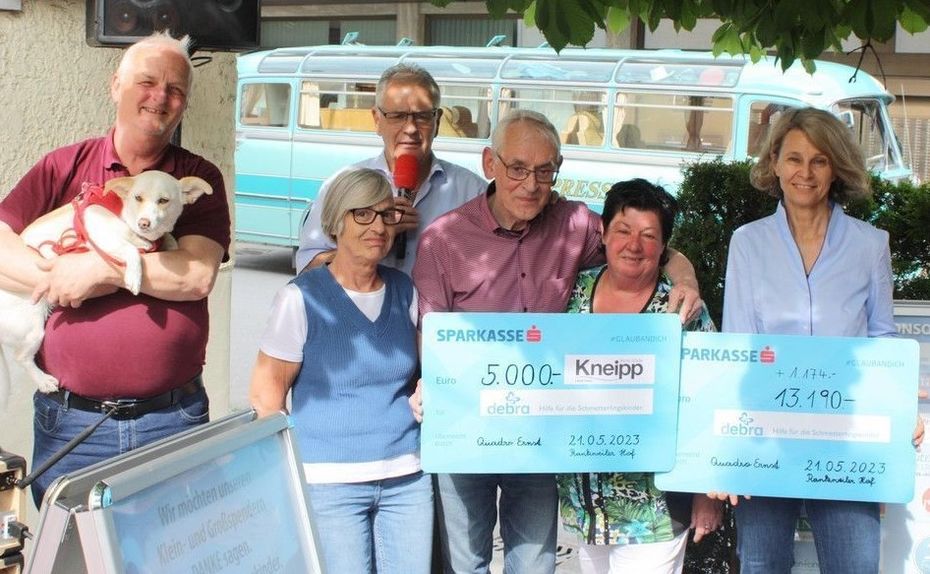 Mehrere Personen halten zwei Spendenschecks