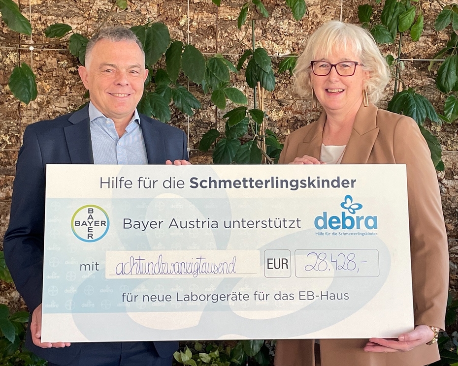 Ein Mann und eine Frau halten einen Spendenscheck 