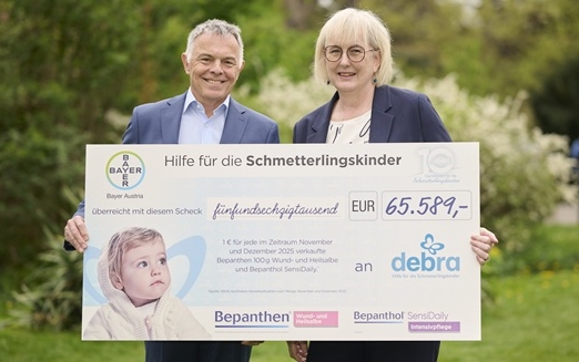 Ein Mann und eine Frau halten einen Spendenscheck