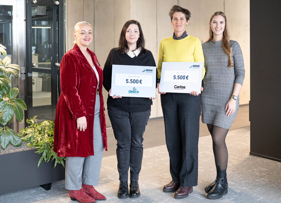 Vier Frauen halten zwei Spendenschecks