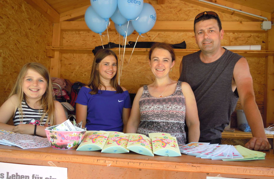 Familie Nöhmer schauen aus dem Infostand heraus.