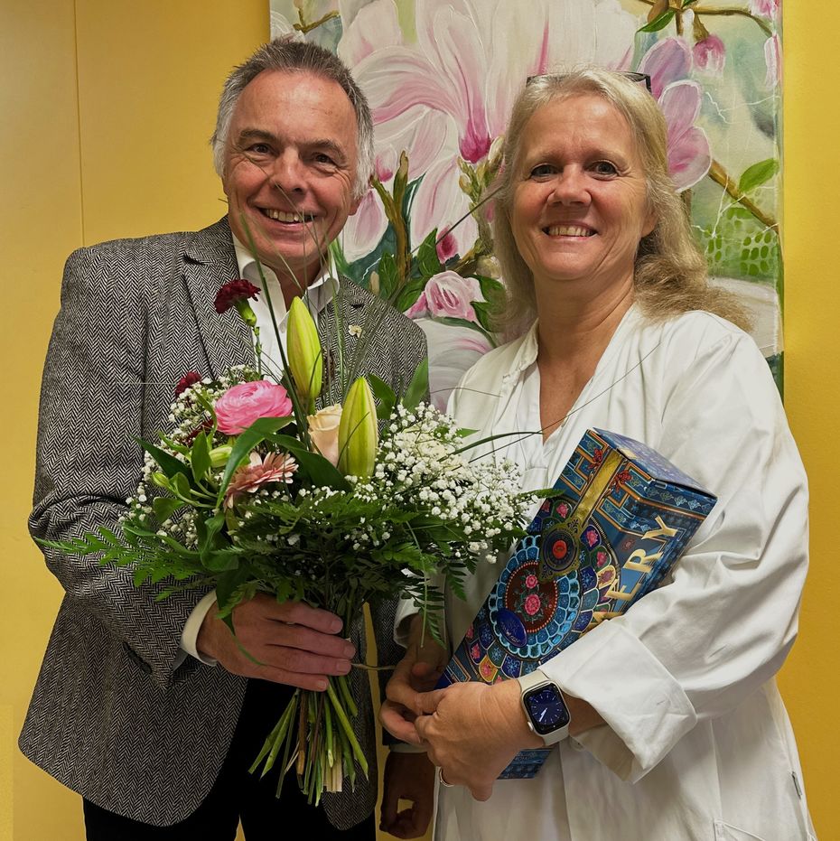 Ein Mann und eine Frau halten einen großen Blumenstrauß