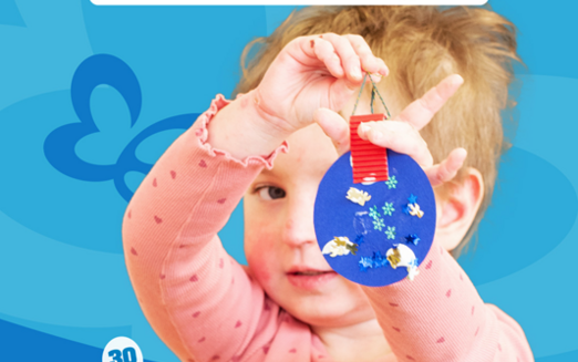 Schmetterlingskind hält eine blaue Papierkugel in der Hand