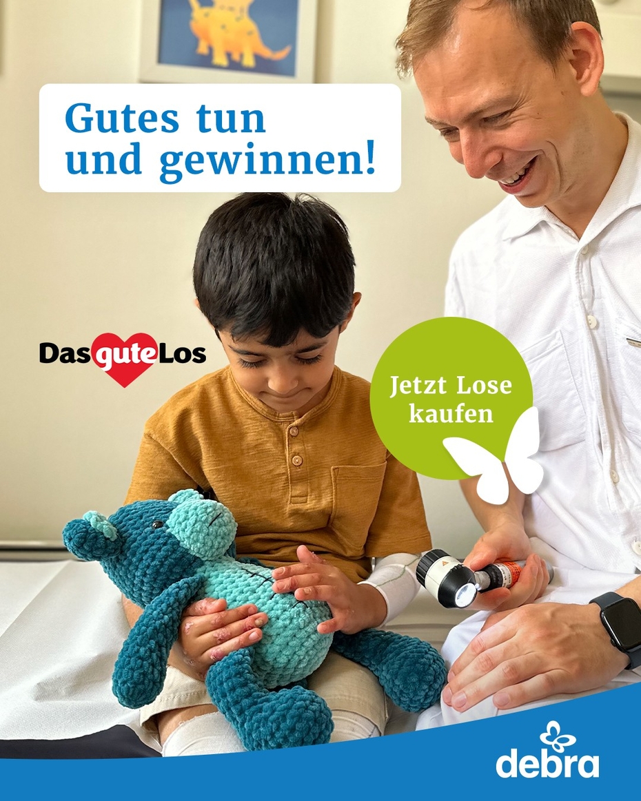 Ein Junge mit EB und ein Arzt sitzen gemeinsam auf einer Behandlungsliege