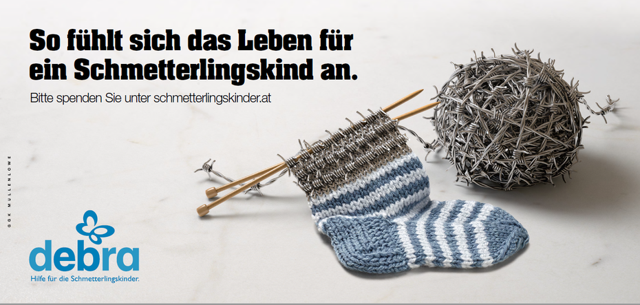 Kampagnensujet Kindersocken mit Knäuel aus Stacheldraht