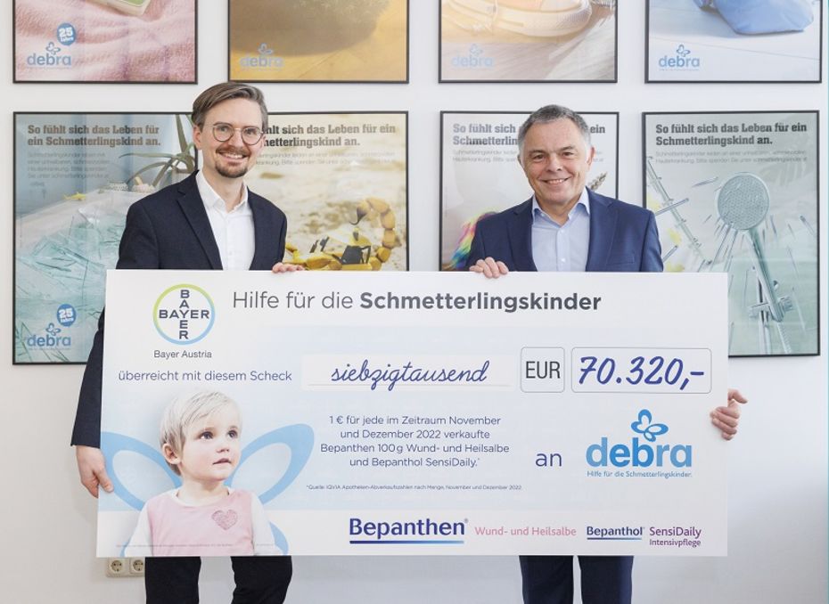 Zwei Männer halten einen Spendenscheck