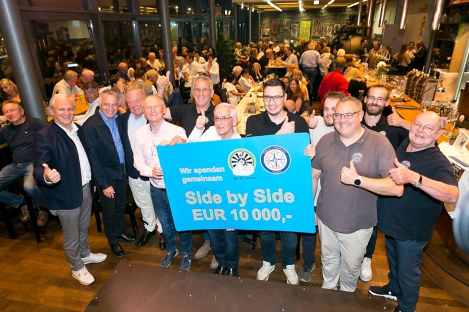 Eine Gruppe von Menschen mit einem blauen Spendenscheck