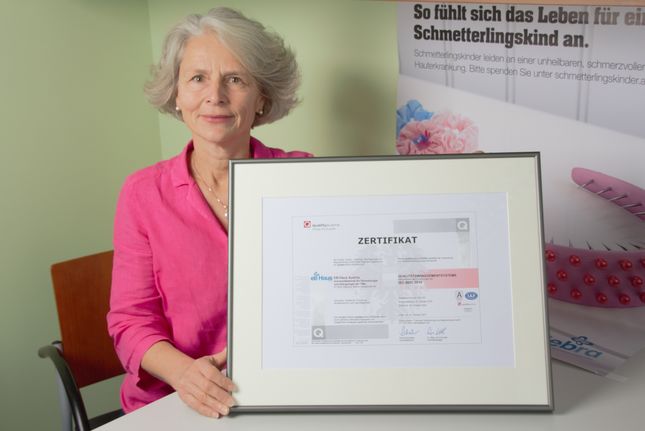 Qualitätsmanagerin des EB-Haus Austria präsentiert Zertifikat