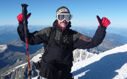 Ein Mann steht in hochalpiner Kleidung im Schnee