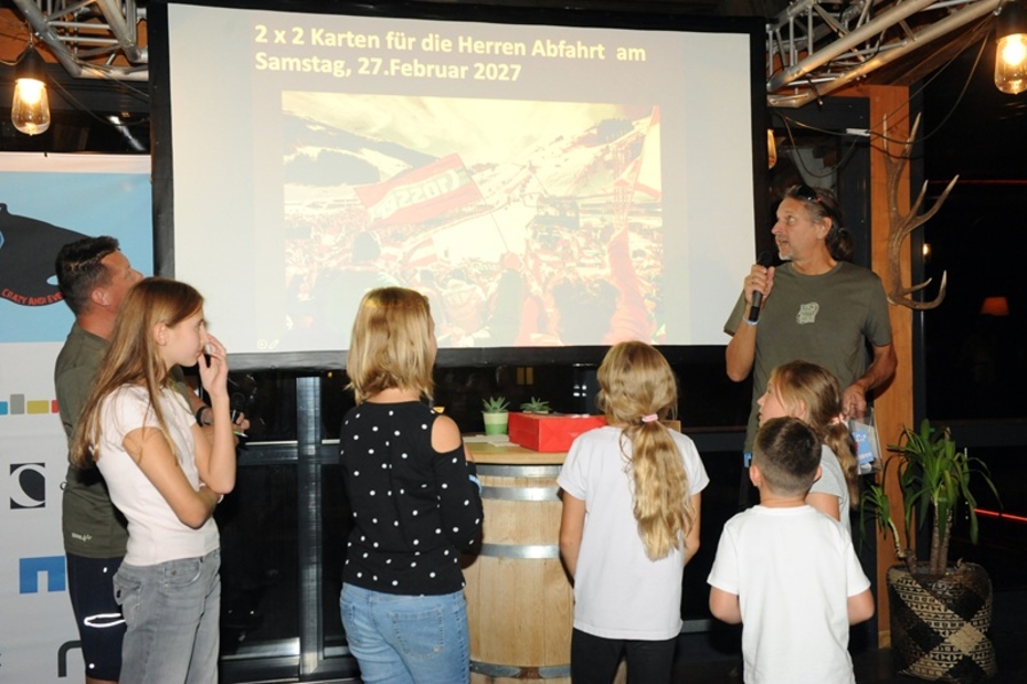 Kinder unterschiedlichen Alters und ein Mann stehen vor einer Leinwand
