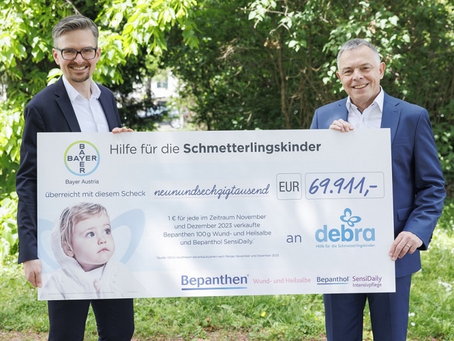 Zwei Männer halten einen großen Spendenscheck