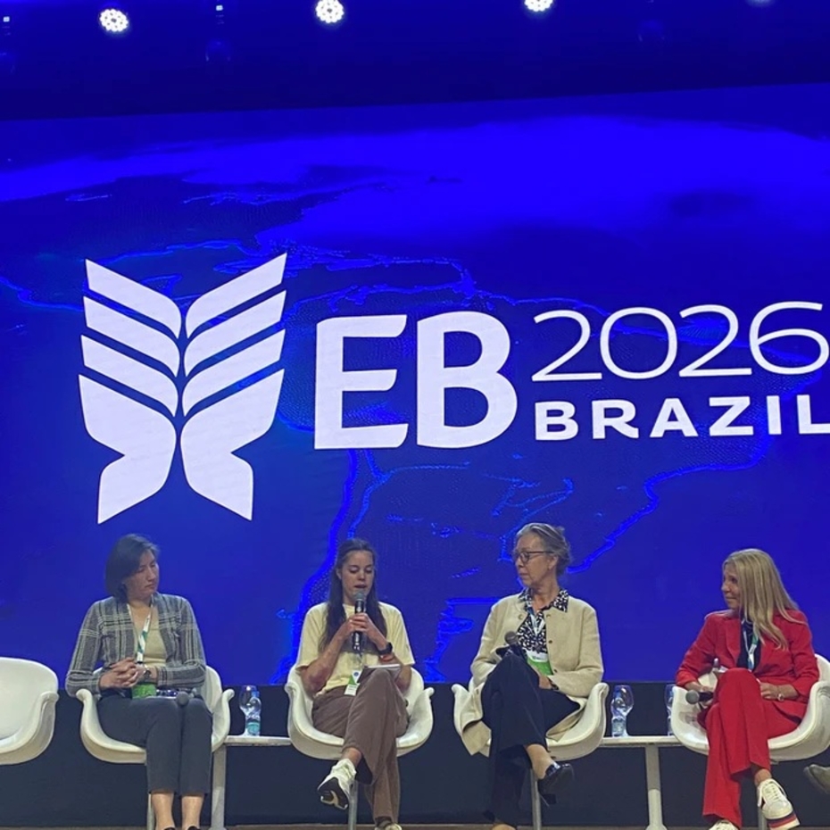 Menschen sitzen auf einer Bühne mit blauem Hintergrund