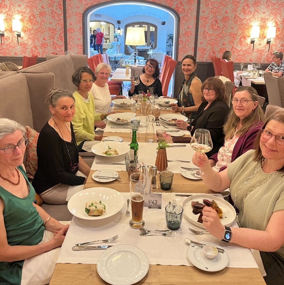 Mehrere Frauen sitzen an einer gedeckten Tafel in einem Restaurant
