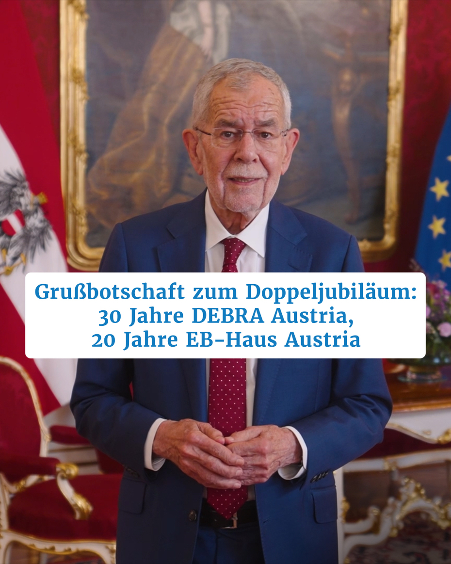 Ein Mann steht vor einer Wand mit roter Tapete