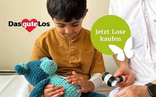 Ein Junge mit EB sitzt auf einer Behandlungsliege, neben ihm ein Arzt