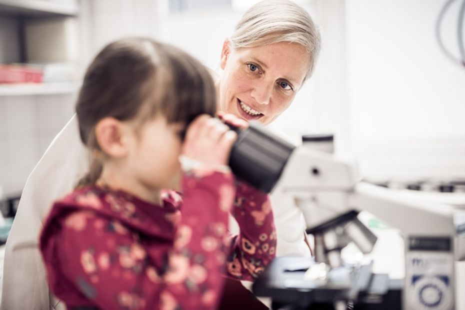 EB-Forscherin Verena Wally und Schmetterlingskind im Labor mit Mikroskop