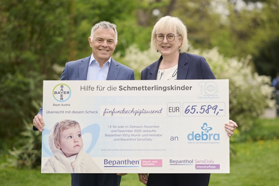 Ein Mann und eine Frau halten einen Spendenscheck