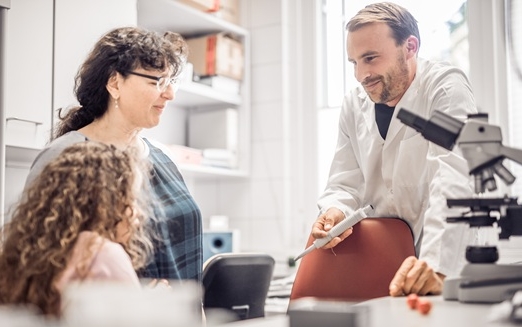 Mutter mit Schmetterlingskind und Forscher in einem Labor