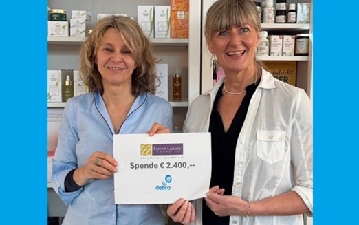 zwei Frauen halten einen Spendenscheck